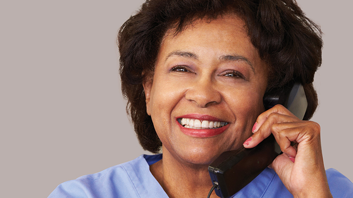 Nurse talks on phone with a smile