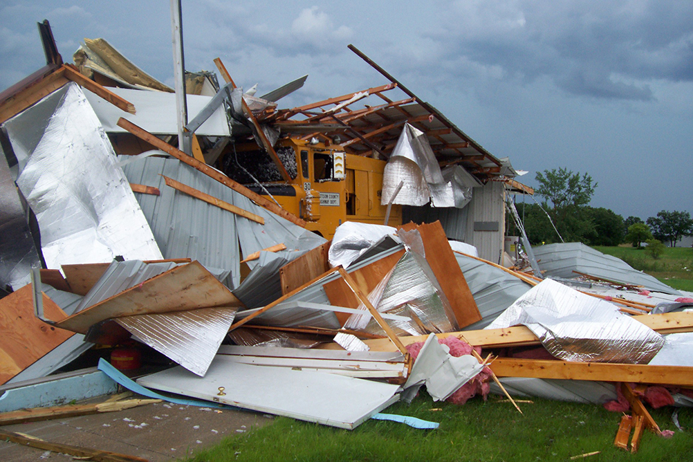 Building walls collapsed around large equipment truck as a result of a storm